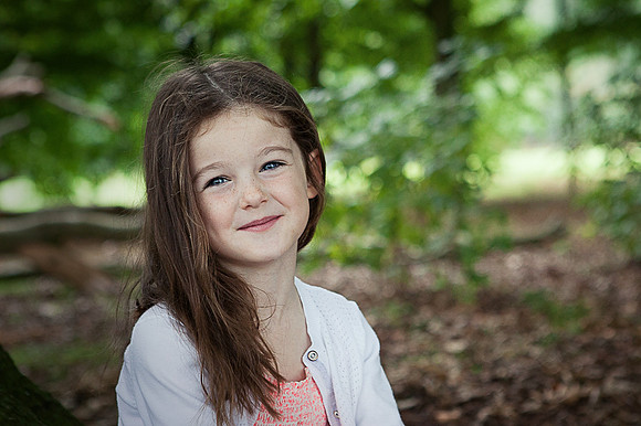 Little girl sits in the woods